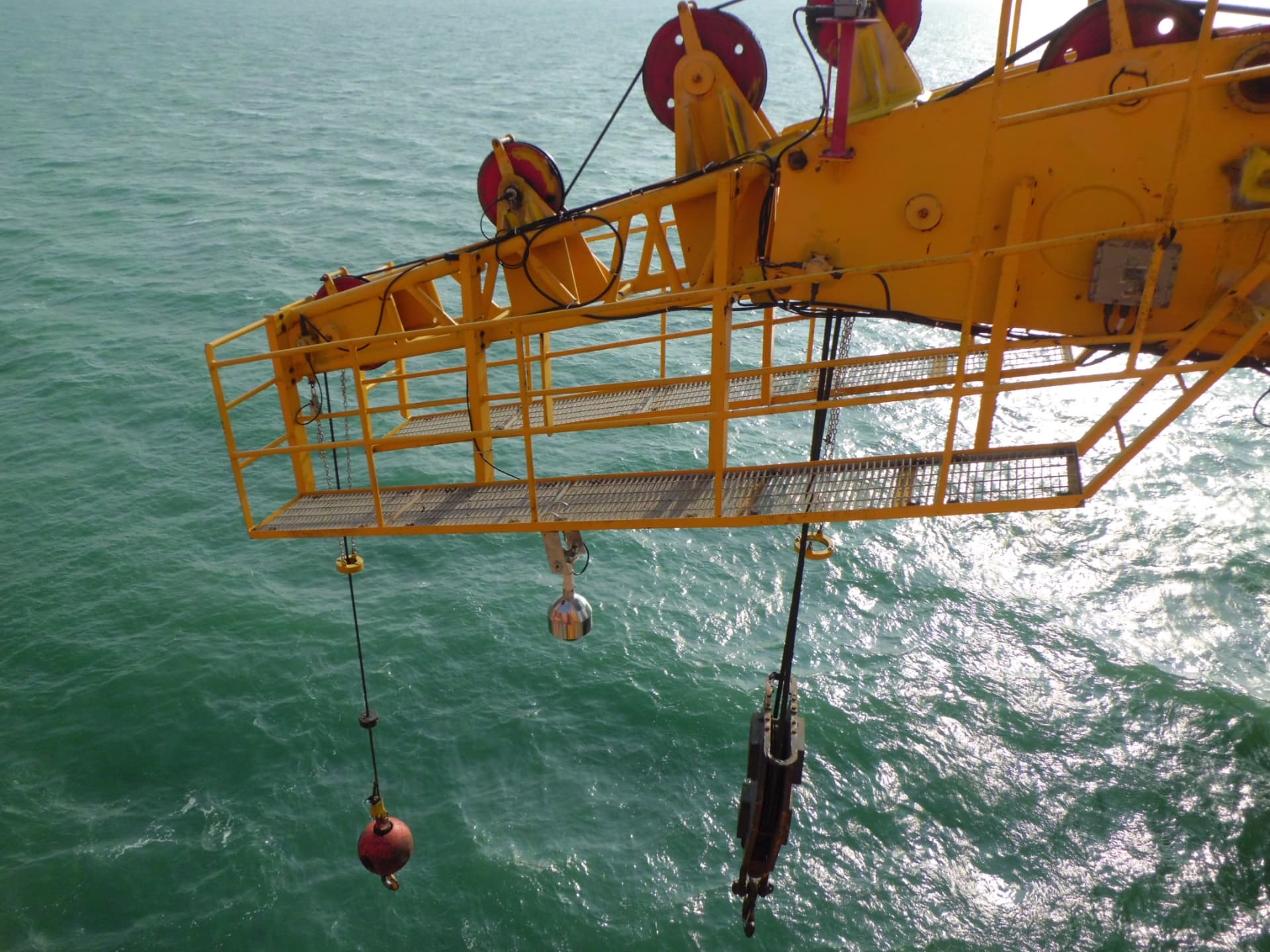 Offshore crane boom tip with anti-two-block and angle sensors above the sea