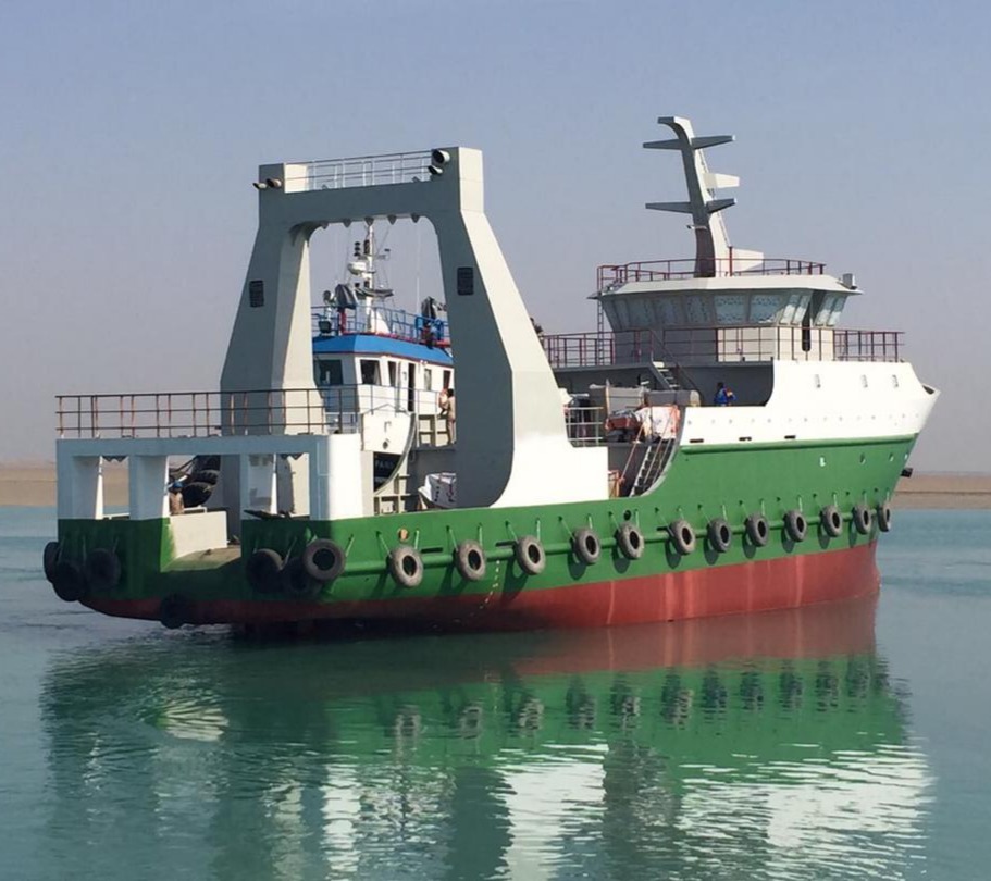 Newly built green and white workboat with A-frame afloat after launch