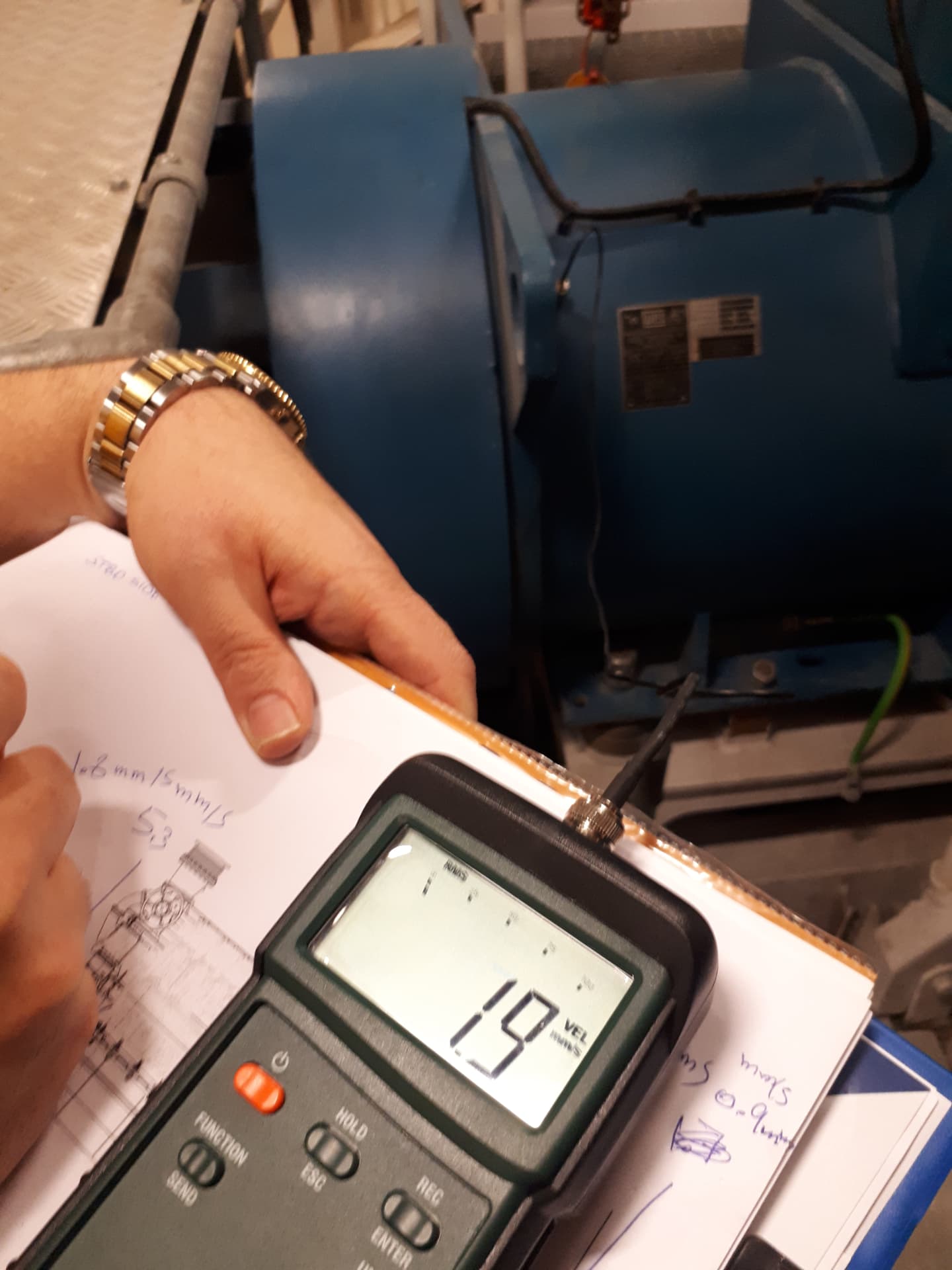 Engineer measuring motor vibration velocity with handheld meter