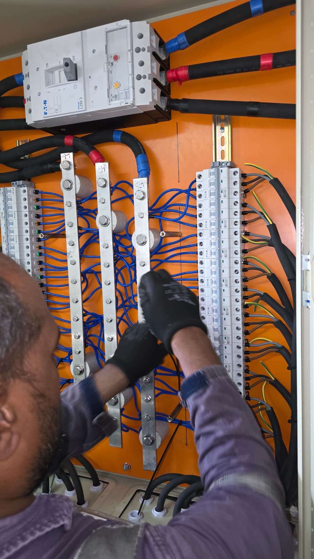 Electrician wiring MCCB and MCB busbars inside a marine switchboard